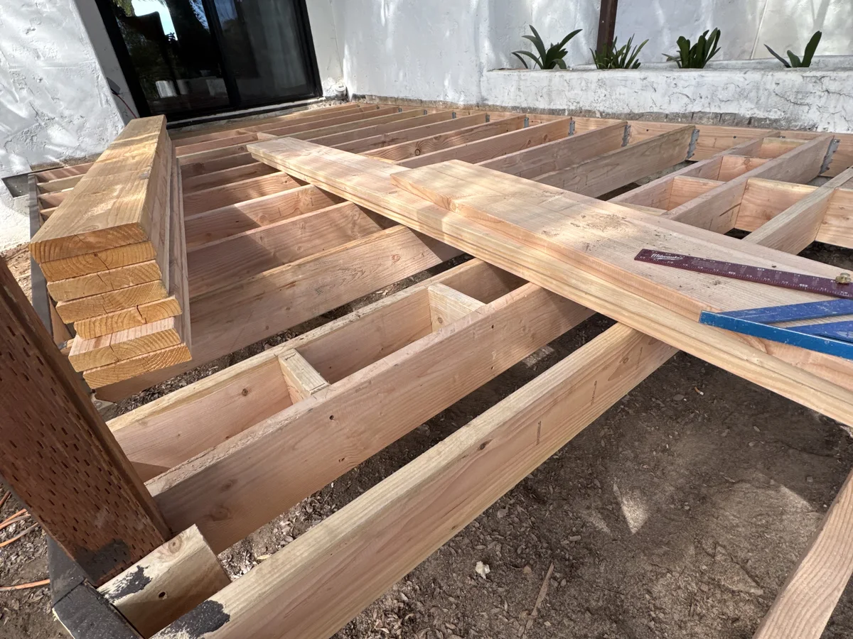 Deck framing and stair construction project photo showing exterior structural carpentry